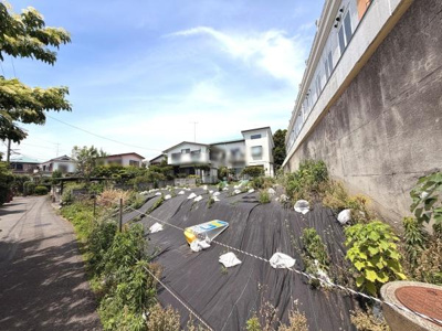 現地は開放感のある角地で前面道路も広々としています。日当たりが良好で周囲の住宅街も落ち着いた雰囲気です。