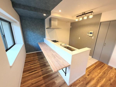 ナチュラルな木目のフローリングとカウンターが調和しています。窓からの採光で明るい空間です。照明もアクセントとなり室内の印象を引き立てています。