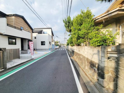 前面道路は広々とした印象で車の出入りもスムーズに行えます。周辺には新しい住宅が建ち並び清潔感のある街並みが特徴です。道路沿いの植栽や塀が落ち着いた雰囲気を演出しています。