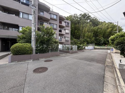 落ち着いた色合いの外観が印象的な建物です。前面の道路はゆとりがあり開放感があります。建物周辺には緑が多く落ち着いた環境が広がっています。整然とした街並みが魅力的です。