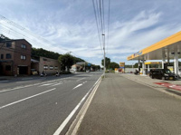 前面道路は幅員が広く車の通行がしやすい印象です。道路沿いにはガソリンスタンドや商業施設があり生活利便性も感じられます。歩道も整備されており安心して歩行できます。周辺には自然も見え落ち着いた雰囲気です。