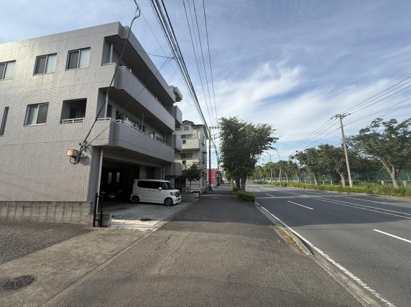 前面道路が広く見通しの良い環境です。建物も手入れが行き届いた印象があります。開放感のある立地で周辺には緑も豊かに見えます。交通の便やアクセスもしっかりと感じられる現地写真です。