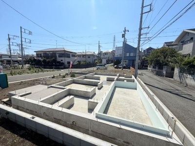 陽当たりの良い立地にある建築中の基礎部分です。周辺は閑静な住宅街でゆとりある道路に面しています。整然とした区画が特徴的です。建築プランに合わせた土台がしっかりと施工されています。