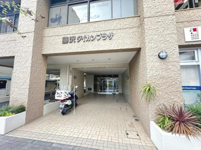 エントランスは広々としたアプローチが確保されております。壁面は落ち着いた色合いで統一されています。建物名がしっかり表記されており来訪者にも分かりやすいデザインです。