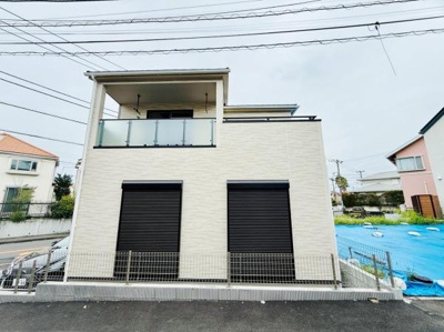 シンプルな外観デザインが印象的な住宅です。バルコニー部分にはガラスフェンスを採用し開放感があります。2階建てで整ったフォルムが落ち着いた雰囲気を演出します。シャッター付きの窓が安全性を高めています。