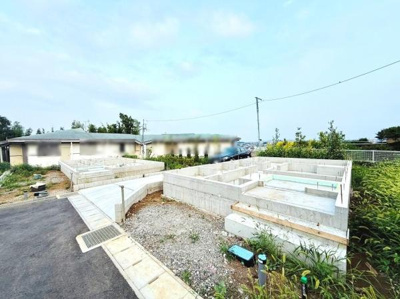 開放感のある外観写真です。閑静な雰囲気で道幅も十分に確保されています。建物の基礎部分が整然と配置されておりこれからの建築が楽しみな一画です。周囲の緑も印象的です。