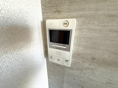 エントランスには見やすい画面付きのインターホンが設置されています。操作ボタンもシンプルで使いやすさが考慮されています。壁面は落ち着いた色調でまとめられており雰囲気を損なわずに設置されています。