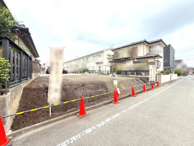 前面道路に面した現地の写真です。道路幅がしっかり確保されており車の出入りもしやすい印象です。周囲は戸建てが立ち並ぶ落ち着いたエリアです。現地の様子が分かりやすい写真です。
