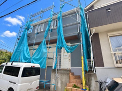 外観は現在工事用の足場とネットで覆われています。敷地は前面道路に面しており周囲には住宅が建ち並んでいます。駐車スペースがある点も特徴です。日当たりの良い位置に建っています。