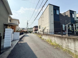 現地の前面道路を含む写真です。建物外観の塗装や工事の様子が分かりやすく撮影されています。足場やネットが設置されており安全面にも配慮されていることがうかがえます。