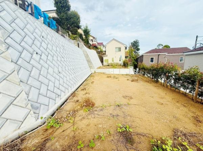 ひな壇状の地形が特長的な敷地です。広々としたスペースが確保されています。周辺には住宅が立ち並び落ち着いた雰囲気を感じられます。日当たりも良好な環境です。宅地の形状がはっきりわかる写真です。