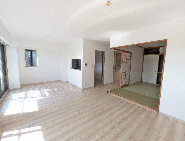 対面キッチンのリビングは明るく開放感があり、和室と続き間で使用できる広々とした空間です