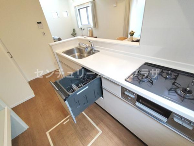 明るい空間に調和したキッチンです。食洗器や三口コンロなど設備が充実しています。使い勝手の良さが際立つレイアウトです。リビングが見渡せる対面式も魅力的です。収納も豊富に確保されています。