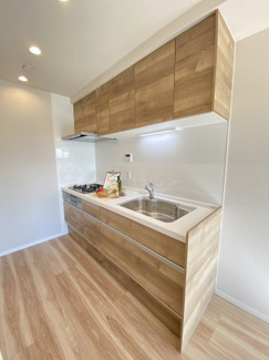 明るい色調の床と壁が清潔感を感じさせる、広々としたキッチン空間です。
シンクやコンロは直線的に配置されており、使い勝手にも配慮されています。