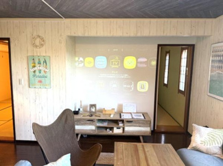 落ち着いたナチュラルなテイストのリビングが魅力の空間です。壁面のプロジェクターがリビングをより一層機能的に演出します。木材の温かみを感じるインテリアが居心地の良さを引き立てています。