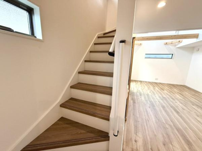 階段部分に手すりが設置されており安心して移動ができます。明るい室内と木目調の床が調和したデザインです。窓からの採光があり室内が明るく保たれます。全体的に開放感のある空間です。