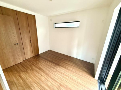 明るい光が差し込む洋室はシンプルなデザインで落ち着いた雰囲気です。大きめのクローゼットが備わっており収納に便利です。木目調のフローリングが温かみを感じさせます。