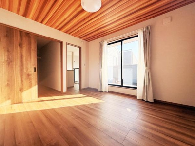 窓から差し込む光が明るい空間を演出しています。天井と床の木目調デザインが統一感を感じさせます。収納扉もお部屋に溶け込むデザインです。使い勝手の良い洋室です。