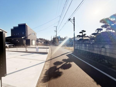 前面道路は舗装されており周辺も整然としています。電線や街路樹が道路沿いに配置されていて落ち着いた印象です。周囲には住宅が立ち並び静かな住環境が感じられます。