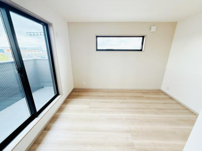 明るい光が差し込む洋室です。シンプルな内装で家具のレイアウトがしやすいです。窓から外の景色が楽しめます。フローリングが清潔感を演出しています。使い勝手のよい形状が特徴です。