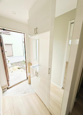 玄関は白を基調としたシンプルなデザインです。大型の収納が備え付けられており整理整頓がしやすい空間です。大きな鏡が設置されているのでお出かけ前の身だしなみチェックに便利です。