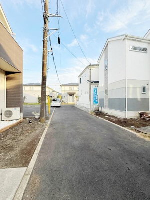 前面道路は幅員が確保されており車の通行や駐車がしやすい環境です。周囲には新しい住宅が建ち並び明るい雰囲気が広がっています。道路沿いに無駄な障害物が少なくすっきりとした印象です。