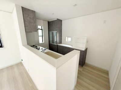 明るく開放感のあるキッチンです。広めのカウンターが特徴で作業しやすい空間となっています。収納スペースが豊富で整理整頓に便利です。床や壁もシンプルな色合いで清潔感があります。