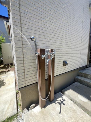 屋外に設置されたシャワー水栓はシンプルなデザインで外観と調和しています。水まわりの利便性を向上させます。ホースの着脱も簡単です。床まわりもすっきりとしています。日常の管理がしやすい配置になっています。