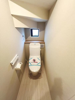 小窓が設置されており換気に配慮されたトイレ空間です。壁リモコンタイプの操作パネルが配置されています。トイレットペーパーホルダーも使いやすい位置に備え付けられています。