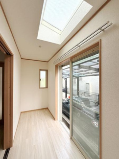 天窓から差し込む自然光が空間を明るく演出しています。スライドドアにより開放感が広がります。フローリングの色合いが穏やかな印象を生み出しています。壁面もすっきりとしたデザインです。