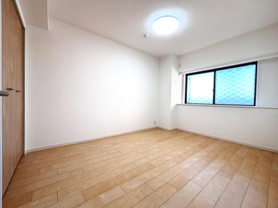 明るい色合いのフローリングが印象的な洋室です。落ち着いた雰囲気の室内で収納スペースも備わっています。窓からの光がしっかり入るため日中も快適に過ごせます。シンプルな内装が使いやすさを感じさせる一室です。