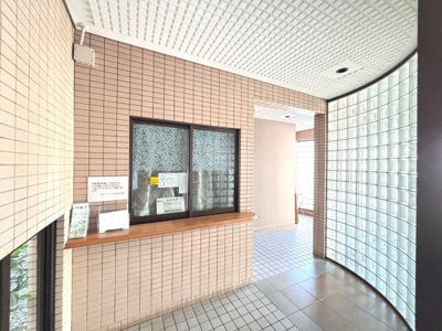 ガラスブロックの壁が特徴的なエントランスです。明るい雰囲気が広がり開放感があります。受付窓口も設けられており安心感を感じられます。タイル貼りの内装が清潔感を演出しています。
