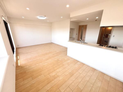 広々としたリビングが開放感を演出します。明るいフローリングが印象的です。対面キッチンから目線が通る間取りです。ダウンライトが天井に美しく並び室内がすっきりとまとまっています。