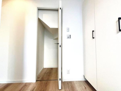 シンプルなデザインの収納扉がすっきりとした空間を演出します。扉の奥には広々としたスペースがあり物の出し入れにも便利です。アクセントとなる取手が印象的です。床の色味と相まって統一感のある印象です。