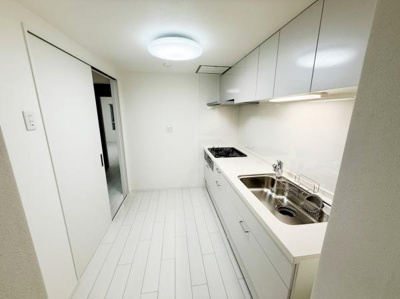 ホワイトを基調としたキッチンは清潔感があります。収納スペースもたっぷり用意されています。使いやすいシンクと調理スペースが配置されています。シンプルなデザインで落ち着いた印象です。