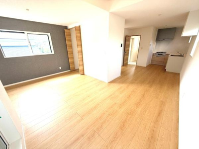 リビングには大きな窓からたっぷりと自然光が差し込み明るく開放的な空間です。白を基調とした内装で全体がすっきりとした印象を与えます。高い天井が特徴で広がりを感じられる設計です。