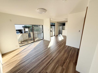 南向きの大きな窓から自然光がたっぷり入るリビングです。床は落ち着いた色合いで空間全体が明るく開放的に感じられます。隣接するキッチンと一体感があり使いやすい間取りです。