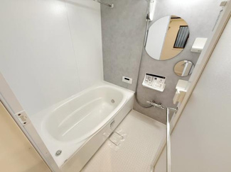 浴室全体が明るく清潔感のある空間です。壁面には大きなミラーと収納棚が付いており使い勝手も配慮されています。浴槽はゆったりとした設計で毎日のリフレッシュに適しています。