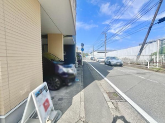 前面道路は広々とした印象で交通量も確認しやすい環境です。建物周辺は舗装が整っており歩道も確保されています。現地の様子が明るく撮影されており全体の雰囲気をつかみやすい写真です。