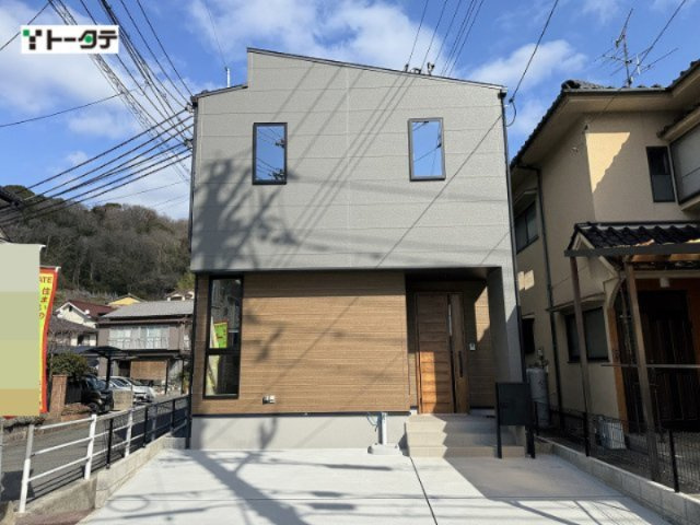 落ち着きのあるグレーに、温かみのある木目調のアクセントウォールを組み合わせたスタイリッシュな外観。