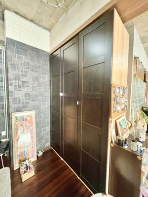 シンプルなデザインの収納が空間に調和しています。天井まである高さで収納力もしっかり確保されています。ダークトーンの扉が落ち着いた雰囲気を演出しています。