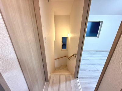 明るい色合いのフローリングが広がる階段と廊下が印象的です。窓からの自然光が差し込み空間全体が開放的な雰囲気となっています。手すりが設置されており安心して上り下りできます。