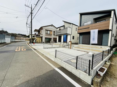 前面道路が広く車の出入りがしやすい配置です。周辺には整った街並みが続いています。新築の住宅が並び清潔感のある現地写真です。シンプルなフェンスで開放感も感じられます。