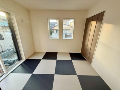 窓からの採光が豊かな和室です。モダンな畳のデザインが印象的な空間となっています。収納スペースもあり使い勝手に配慮されています。バルコニーへのアクセスも便利な配置です。明るい雰囲気が魅力の和室です。