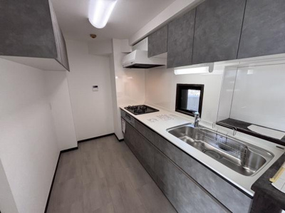 シンプルなデザインで落ち着いた色合いが空間全体に調和しています。収納スペースがしっかり確保されており作業スペースも広々としています。窓付きで明るさと換気が期待できます。