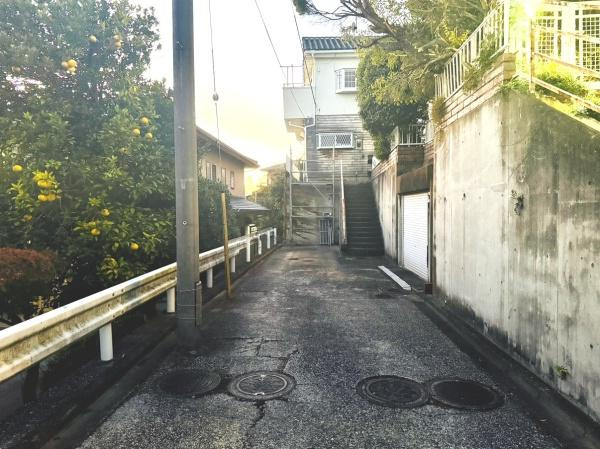 前面道路は舗装されており安心してご利用いただけます。周囲には緑も感じられ落ち着いた雰囲気が広がっています。敷地へのアクセスもスムーズで現地の様子がよく分かります。