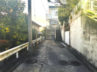 前面道路は舗装されており安心してご利用いただけます。周囲には緑も感じられ落ち着いた雰囲気が広がっています。敷地へのアクセスもスムーズで現地の様子がよく分かります。