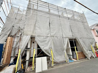 現在建築中の物件で前面にはしっかりとした足場と養生が施されています。作業の工程を間近で確認できるため安心感があります。道路に面した立地でアクセスも良好です。外観の仕上がりが楽しみな一軒です。