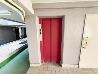 赤い扉が印象的なエレベーターが設置されています。廊下からのアクセスがしやすく快適です。エレベーター横にもスペースが確保されています。共用部の状態も良好です。日々の移動もスムーズに行えます。