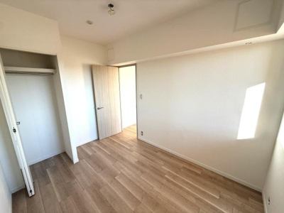 明るい日差しが差し込む洋室です。ナチュラルなフローリングが特徴的です。シンプルな内装で幅広いインテリアに合わせやすい空間です。収納スペースも備わっておりお部屋をすっきりと使えます。